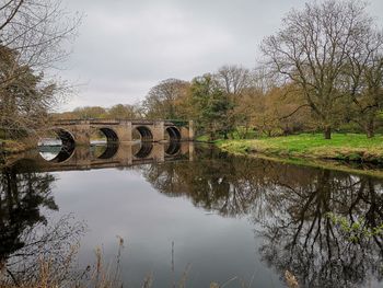 Arch bridge over lake against sky