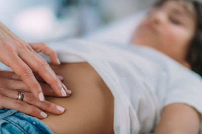 Pediatrician gastroenterologist, examining preschooler boys abdomen.