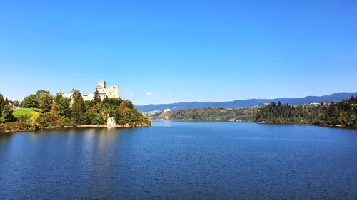 Scenic view of lake against clear blue sky