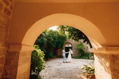 Side view of couple standing by building