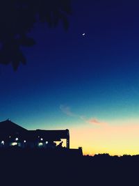 Illuminated built structures against clear sky at dusk