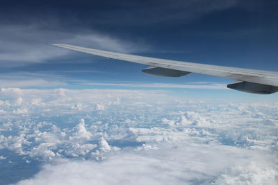 Aerial view of aircraft wing over clouds