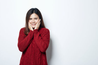 Portrait of a smiling young woman against white background
