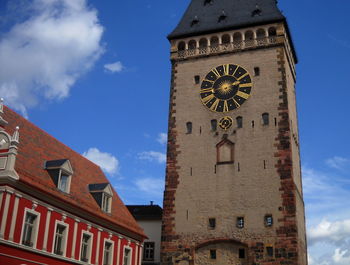 Low angle view of clock tower against cloudy sky