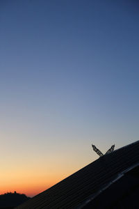 Low angle view of silhouette building against clear sky