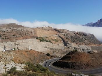 Scenic view of mountain road against cloudy sky