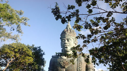 Low angle view of statue against trees