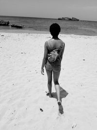 Rear view full length of woman walking at beach