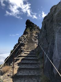 Low angle view of staircase leading towards mountain against sky