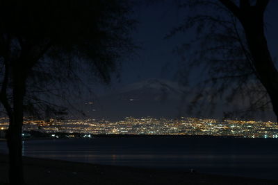 Illuminated city against sky at night