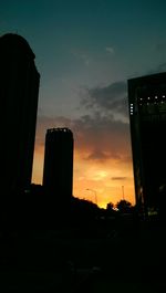 Low angle view of buildings against cloudy sky