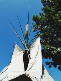 Low angle view of clothes hanging against clear blue sky