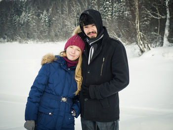 Portrait of smiling man and woman in snow