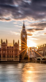 View of big ben from river against cloudy sky