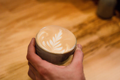 Close-up of hand holding coffee cup