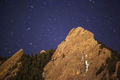 Low angle view of rocks against sky at night