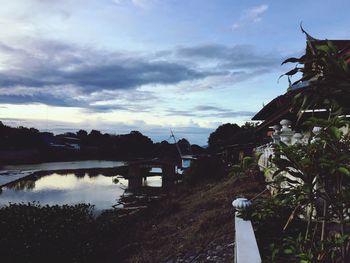 Bridge over river by buildings against sky