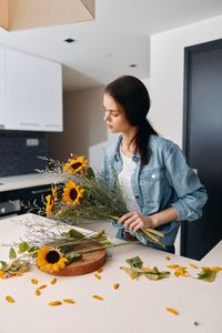 Portrait of young woman preparing food at home