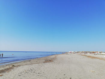 Scenic view of beach against clear blue sky