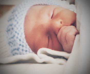 Close-up of baby sleeping on bed