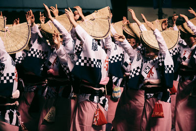 Women dancing with arms raised during awa dance festival