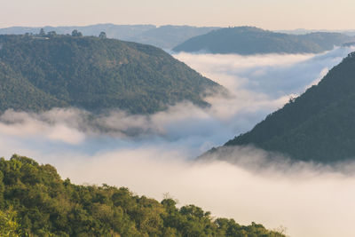 Scenic view of mountains against sky with cloud inversion