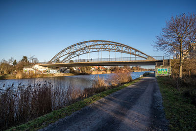 Bridge over river against clear blue sky