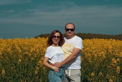 Portrait of smiling standing on field against sky