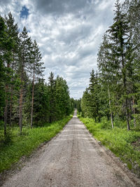 Road amidst trees against sky