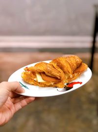 Close-up of hand holding ice cream cone in plate