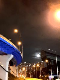 Low angle view of illuminated street lights at night