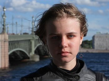 Portrait of young woman standing against buildings