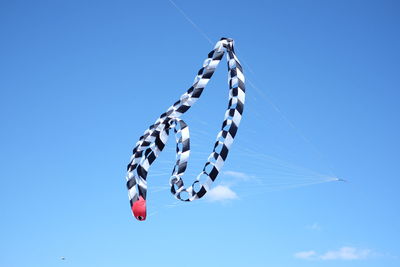 Low angle view of hanging lights against clear blue sky