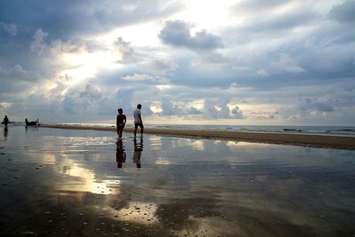 People on beach against sky