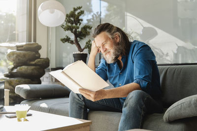 Man sitting on sofa at home