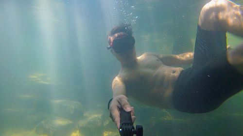 Young man swimming in lake