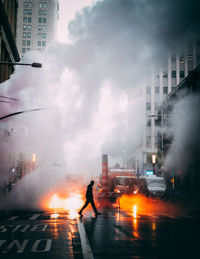 Man walking on street against buildings in city