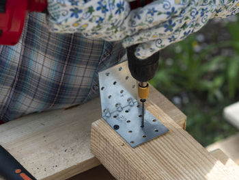 Low section of woman holding umbrella on wood