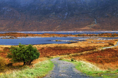 Scenic view of lake by mountain against sky