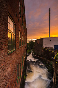 Water flowing down besides old industry buildings