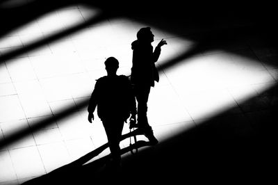 High angle view of silhouette people walking on floor