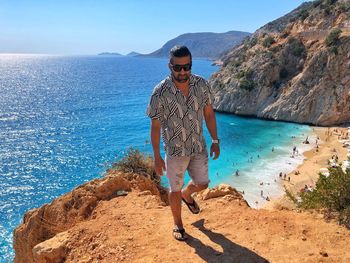 Full length of young man on rock at beach