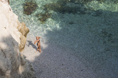 High angle view of woman in bikini standing at beach