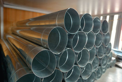 Close-up of stacked metal pipes on table