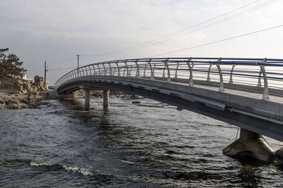 Low angle view of bridge over sea against sky