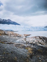 Scenic view of sea and snowcapped mountains against sky