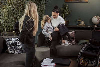 Woman carrying girl from sofa