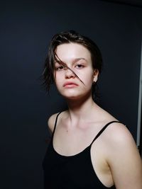 Portrait of beautiful young woman against black background