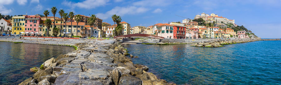 Panoramic view of town by sea against sky