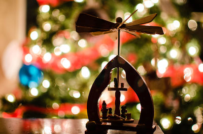 Close-up of decoration on table against christmas tree